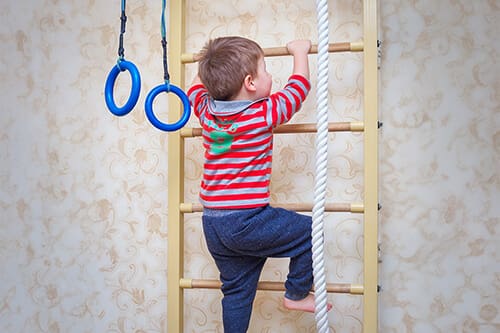 Une zone de jeux d'escalade, où un enfant est en train de grimper une échelle.